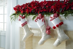 Red poinsettias on holiday mantel with white stockings