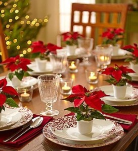 small red poinsettias on plates at Christmas table
